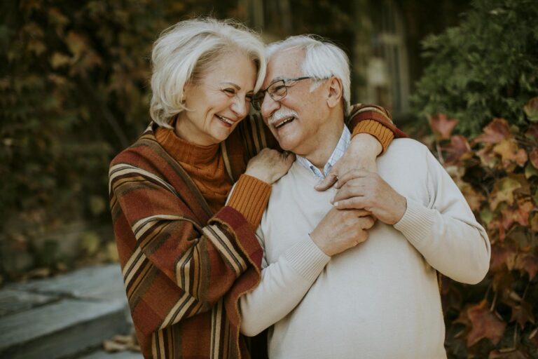 Handsome senior couple embracing in autumn park